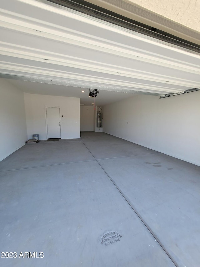 garage with electric water heater and a garage door opener