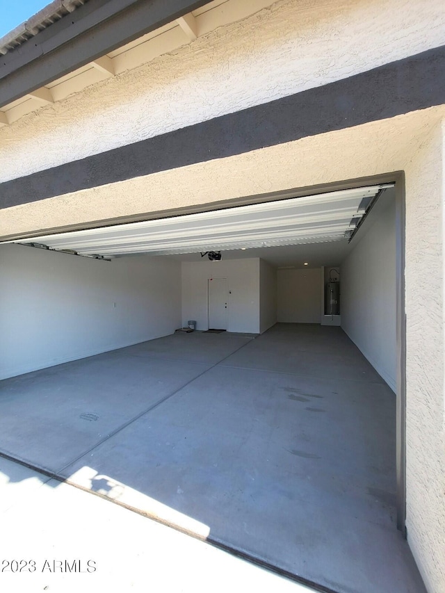 garage featuring electric water heater and a garage door opener