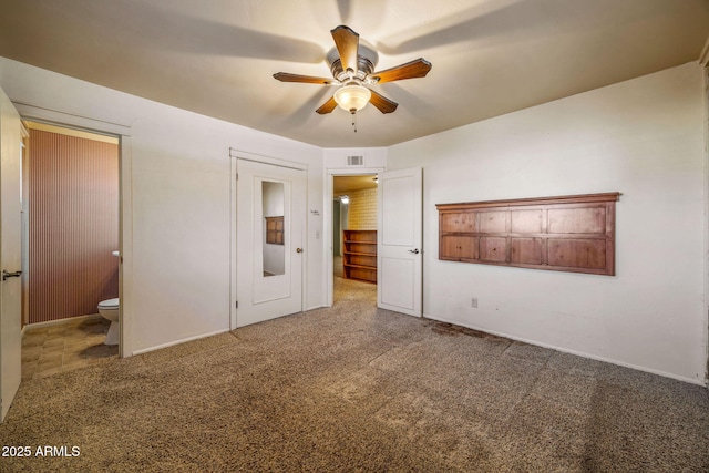 unfurnished bedroom with ceiling fan, visible vents, carpet floors, and connected bathroom