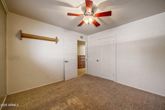 unfurnished bedroom with visible vents, carpet, and a ceiling fan