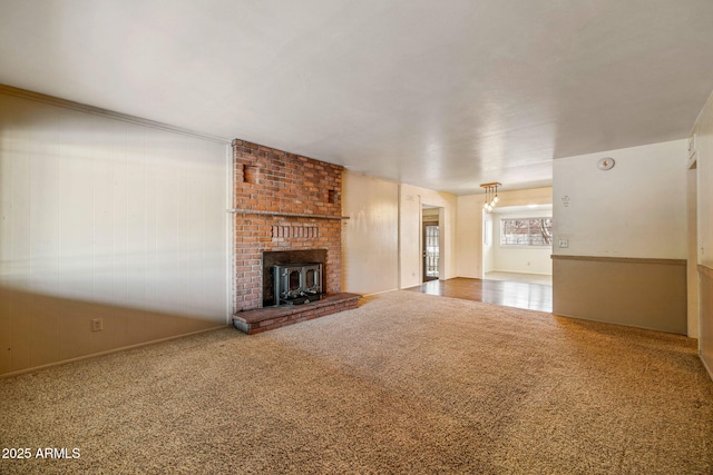 unfurnished living room featuring wooden walls and carpet flooring