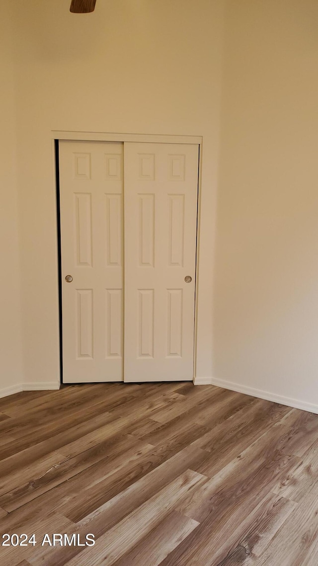 unfurnished bedroom with hardwood / wood-style flooring and a closet