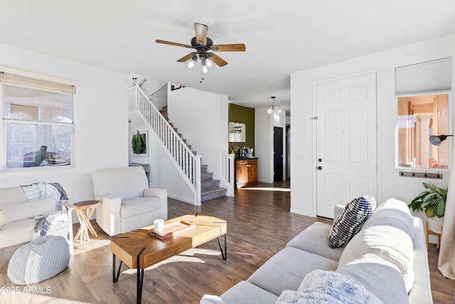 living area with ceiling fan, stairway, baseboards, and wood finished floors