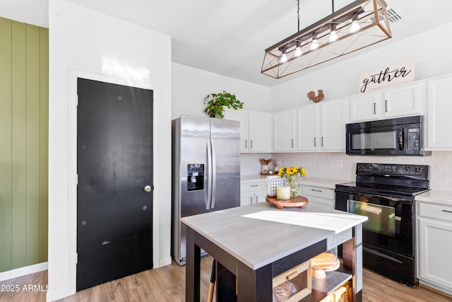 kitchen with backsplash, black appliances, light countertops, and white cabinetry