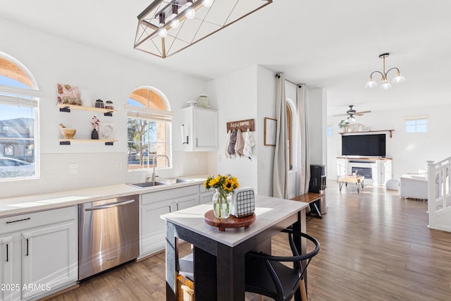 kitchen with decorative backsplash, dishwasher, wood finished floors, and a sink