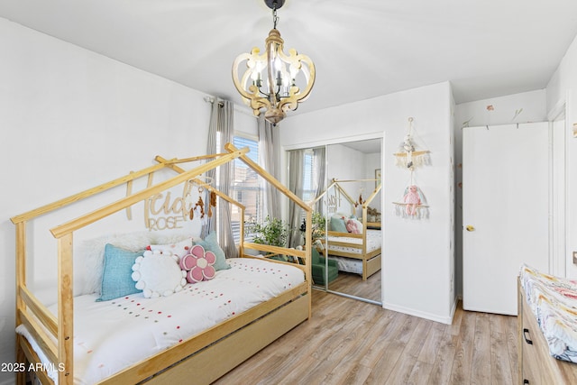 bedroom with a chandelier and wood finished floors