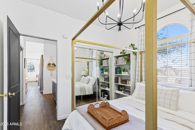 bedroom with multiple windows, dark wood-style floors, a closet, and a chandelier