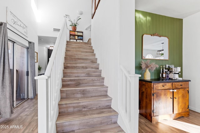 stairway with visible vents and wood finished floors