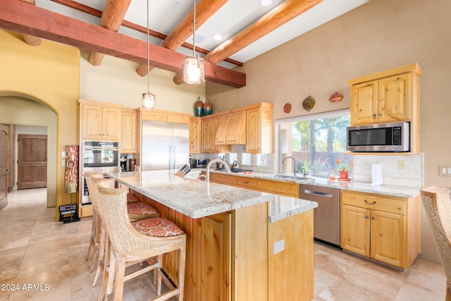 kitchen with an island with sink, stainless steel appliances, backsplash, and light brown cabinetry