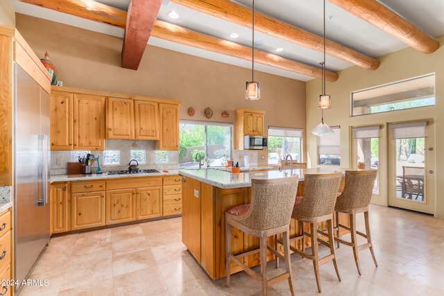 kitchen featuring a center island, hanging light fixtures, stainless steel appliances, beam ceiling, and tasteful backsplash