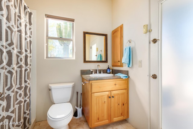 bathroom with tile flooring, toilet, and large vanity