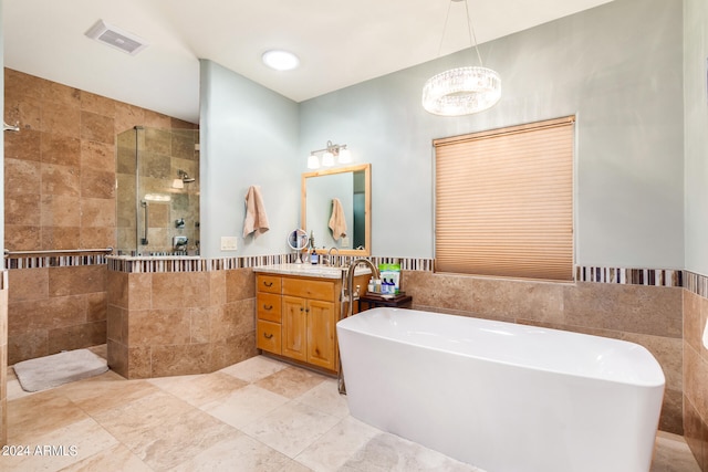 bathroom featuring tile flooring, vanity, tile walls, and plus walk in shower