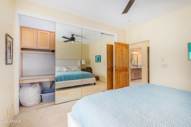 bedroom with ceiling fan, a closet, light carpet, and ensuite bathroom