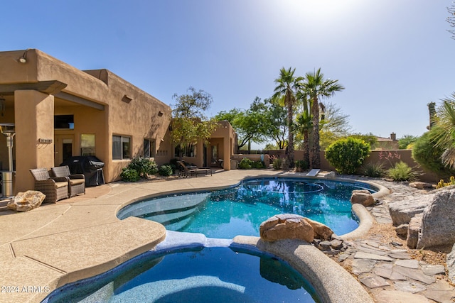 view of pool featuring grilling area, an in ground hot tub, and a patio