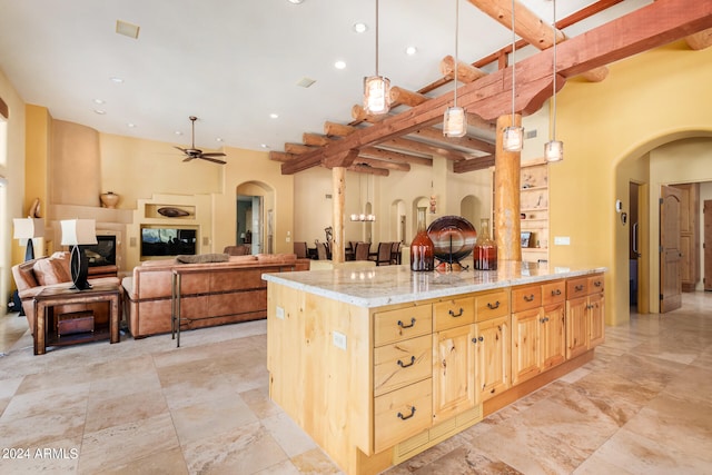 kitchen featuring beamed ceiling, hanging light fixtures, light tile floors, and a kitchen island