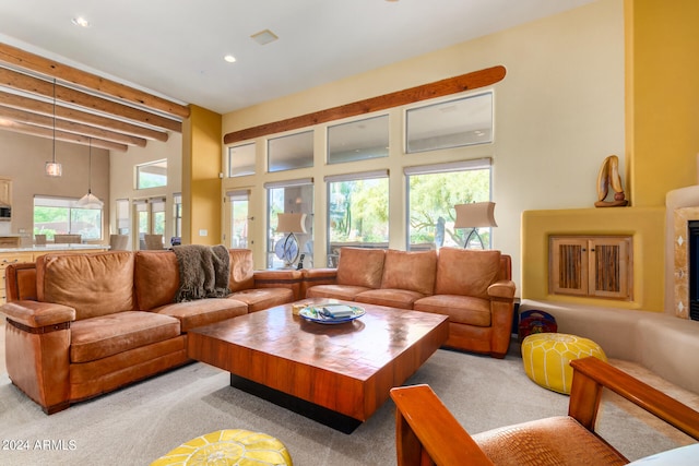 living room with beamed ceiling, a towering ceiling, and carpet flooring