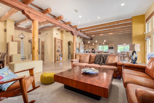 tiled living room featuring beamed ceiling and a towering ceiling