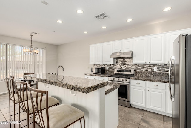 kitchen with white cabinets, appliances with stainless steel finishes, visible vents, and under cabinet range hood