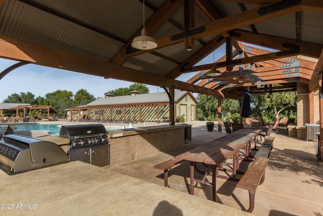 view of patio with an outdoor kitchen, outdoor dining space, an outdoor pool, and a grill