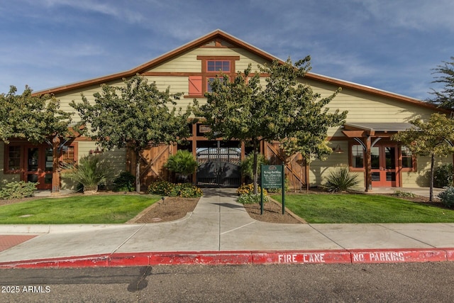 view of front of property with french doors, fence, a front lawn, and a gate