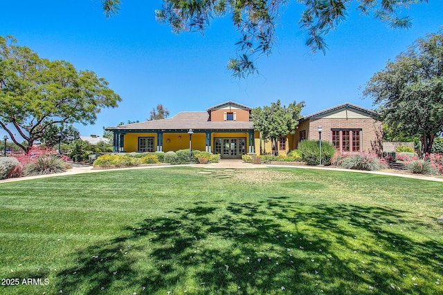 view of front of property with a front lawn and french doors