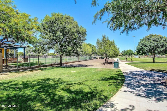 view of community featuring fence and a lawn