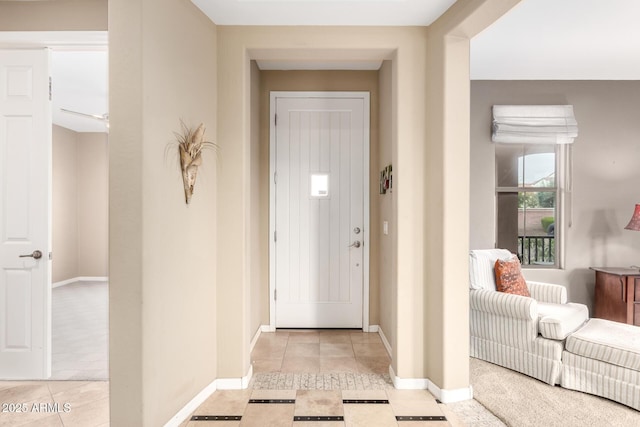 foyer entrance with light tile patterned flooring and baseboards