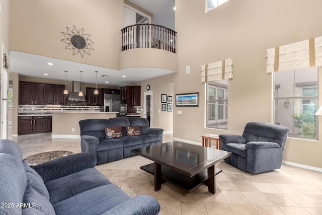 living area featuring a wealth of natural light, baseboards, and a high ceiling