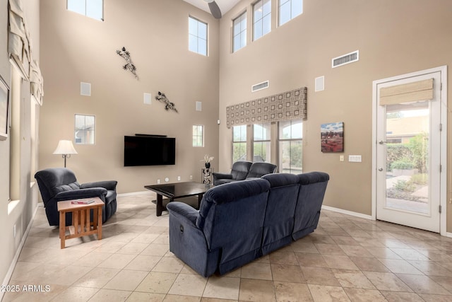 living room with light tile patterned floors, visible vents, and baseboards