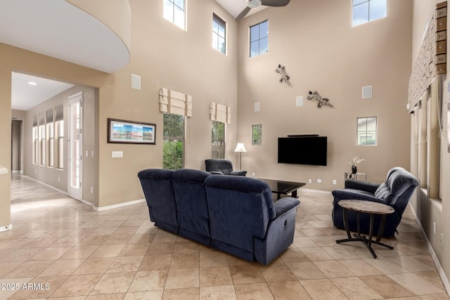 living area with light tile patterned floors, visible vents, baseboards, and ceiling fan