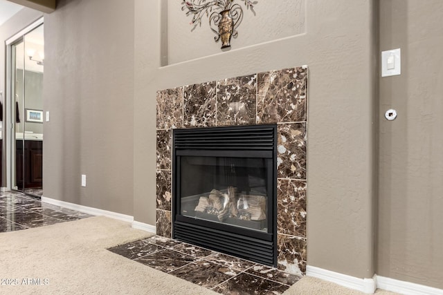 details with baseboards and a tiled fireplace