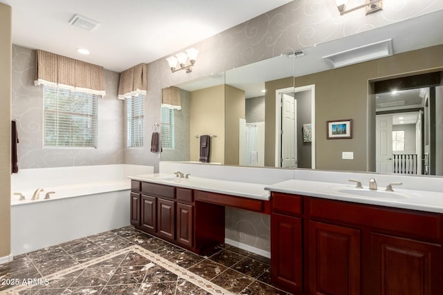 full bath featuring a sink, visible vents, a garden tub, and double vanity