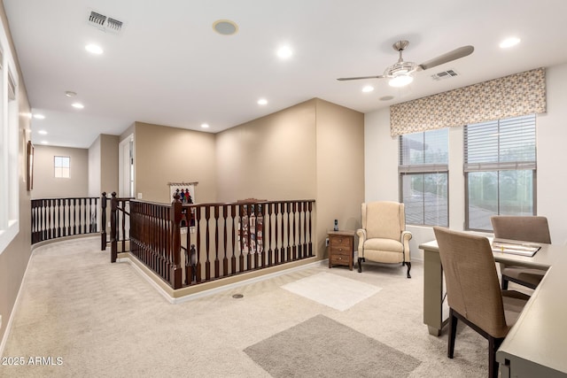 office with light carpet, visible vents, and a ceiling fan