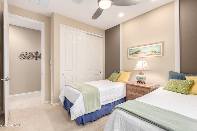 carpeted bedroom with visible vents, baseboards, a closet, and a ceiling fan