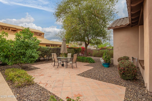 view of patio featuring outdoor dining space and fence