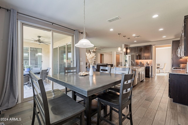 dining room featuring hardwood / wood-style floors, sink, and ceiling fan