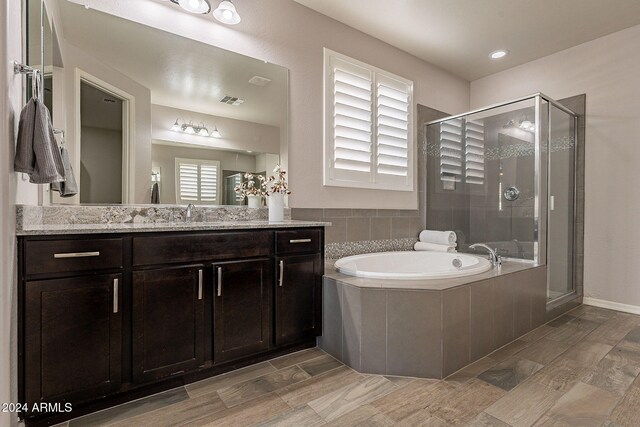 bathroom with vanity and independent shower and bath