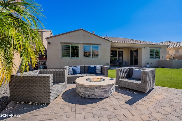 back of house featuring a patio, an outdoor living space with a fire pit, and a lawn