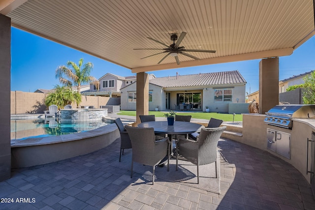 view of patio with an outdoor kitchen, area for grilling, and ceiling fan