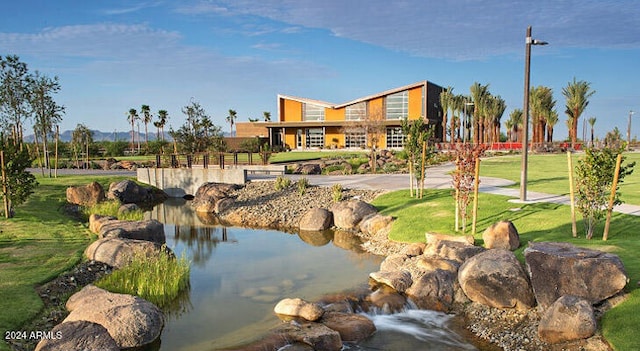 view of property's community featuring a yard and a water view