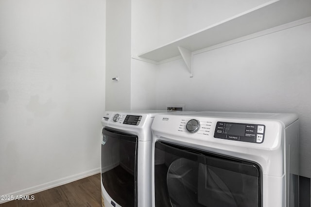 clothes washing area with dark wood-type flooring and washer and dryer