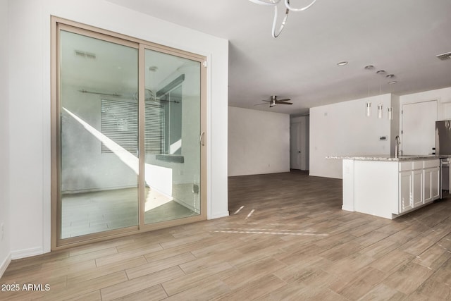 unfurnished living room with sink and ceiling fan