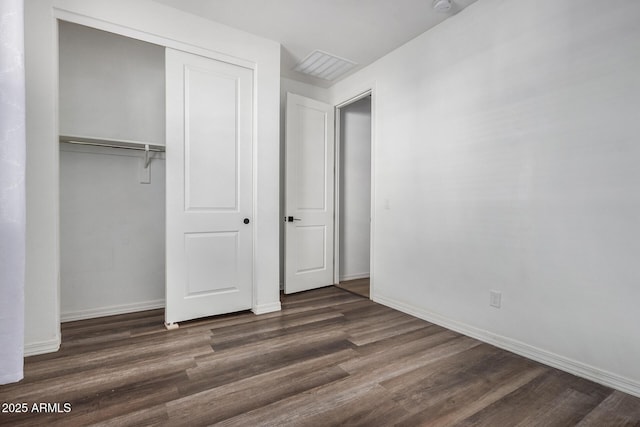 unfurnished bedroom with a closet and dark hardwood / wood-style flooring