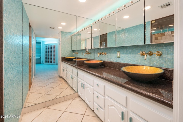 bathroom featuring tile patterned flooring, vanity, and backsplash