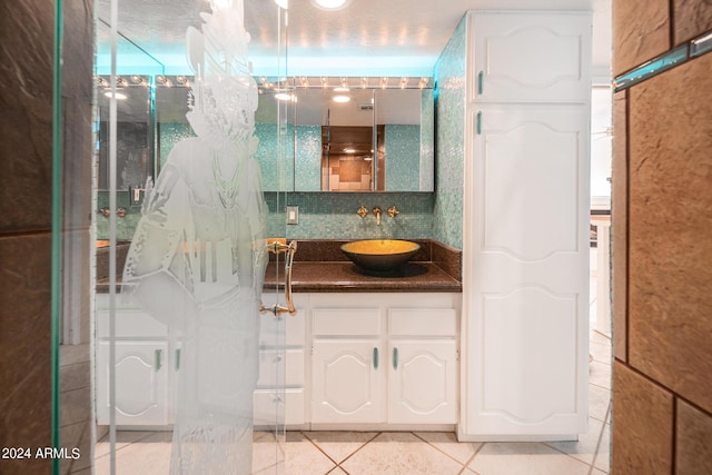 bathroom with decorative backsplash, vanity, tile patterned floors, and walk in shower