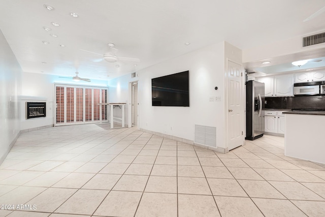 unfurnished living room featuring ceiling fan and light tile patterned flooring