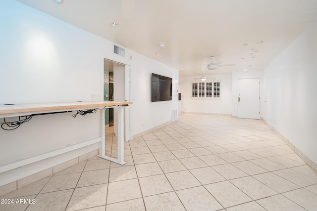 interior space with ceiling fan and light tile patterned floors