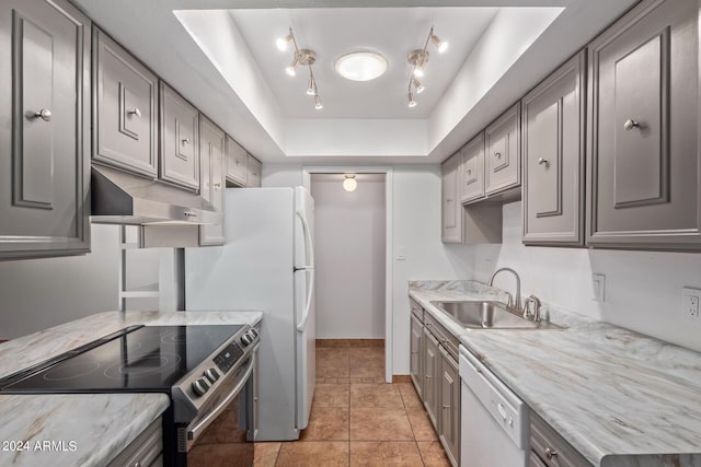 kitchen featuring sink, dishwasher, stainless steel range with electric stovetop, gray cabinetry, and a tray ceiling