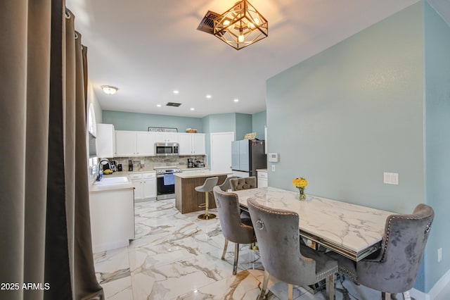 1107 E Ln Salle St, Phoenix, AZ 85040 - dining room featuring a chandelier, light marble finish flooring, and recessed lighting