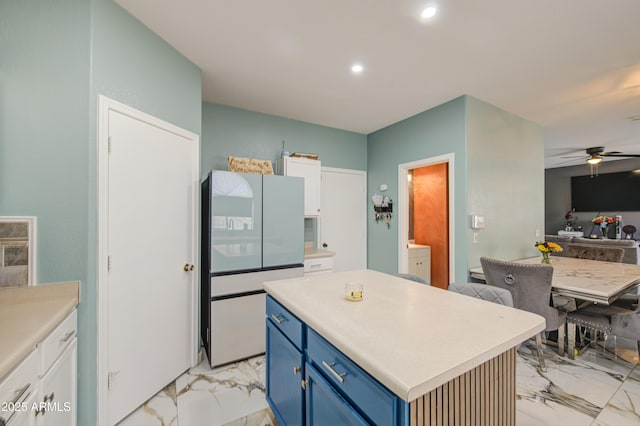 1107 E Ln Salle St, Phoenix, AZ 85040 - kitchen with blue cabinetry, light marble finish flooring, freestanding refrigerator, a ceiling fan, and light countertops